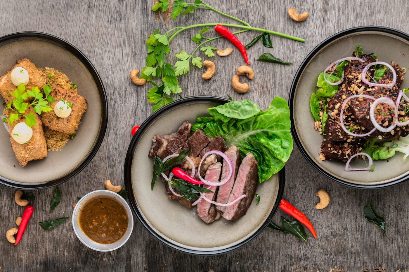 Plated restaurant dishes featuring sliced meats and fresh garnishes